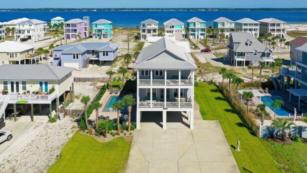 A coastal residential area with houses featuring balconies, a swimming pool, and a view of the ocean. - Awesome Beach House, Private Pool, Gulf View (Navarre)