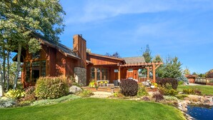 Ein modernes Holzhaus mit Terrasse, Swimmingpool und gepflegtem Garten.