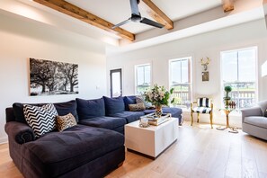A spacious living room with a dark sofa, a coffee table, and a large window. - PGA Championship Home - 10 min to Valhalla Golf Club (Simpsonville)