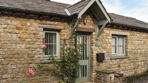 A stone cottage with a green door, two windows, and a sign reading "Mount Cottage". - 1 bedroom accommodation in Tatham, near Lancaster (Tatham, near Lancaster)