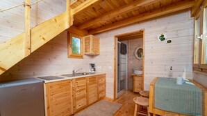 A compact kitchen with wooden cabinets, a sink, and a refrigerator.