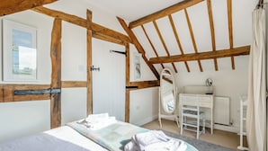 Een slaapkamer met een bed, een dressoir, een spiegel en een radiator.