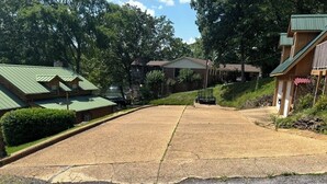 A residential area with a paved driveway leading to a house with a green roof. - Stenson Hollow Lake Condo (Muscle Shoals)