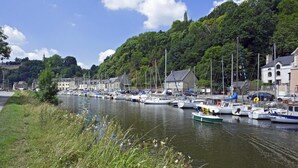 Een jachthaven met boten afgemeerd langs een rivier, omringd door weelderige begroeiing en gebouwen.
