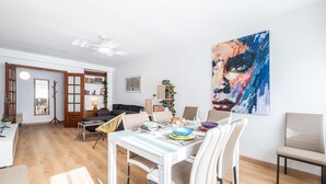 A modern living room with a dining area, wooden flooring, and a ceiling fan. - Stunning apartment in El Campello with WiFi (El Campello)