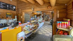 A cozy wooden interior with a checkered floor, a counter with various items, and a display of packaged goods. - 1 bedroom cozy home in Grue Finnskog (Grue Finnskog)
