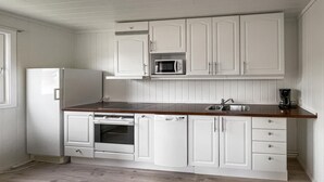 A compact kitchen with white cabinetry, a built-in microwave, a coffee maker, and a dishwasher. - 1 bedroom cozy home in Grue Finnskog (Grue Finnskog)
