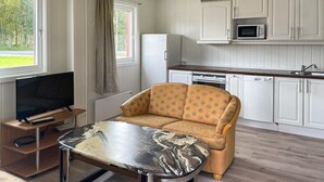 A compact living space with a sofa, a TV, a dining table, and a kitchen area including a microwave and dishwasher. - 1 bedroom cozy home in Grue Finnskog (Grue Finnskog)