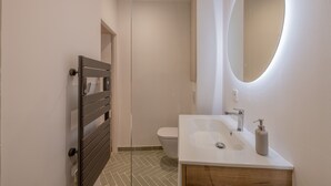 A modern bathroom with a white sink, a mirror, and a toilet. - Appartement de Charme Aix en Provence (Aix-en-Provence)