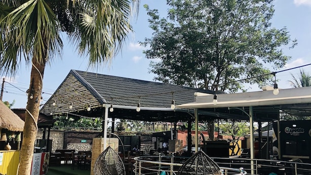 A pool area with lounge chairs, a covered seating area, and a thatched-roof structure. - Esporta Suites Hotel GRA (Lagos)