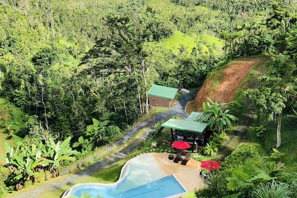 Una piscina al aire libre, sombrillas, sillones reclinables de piscina