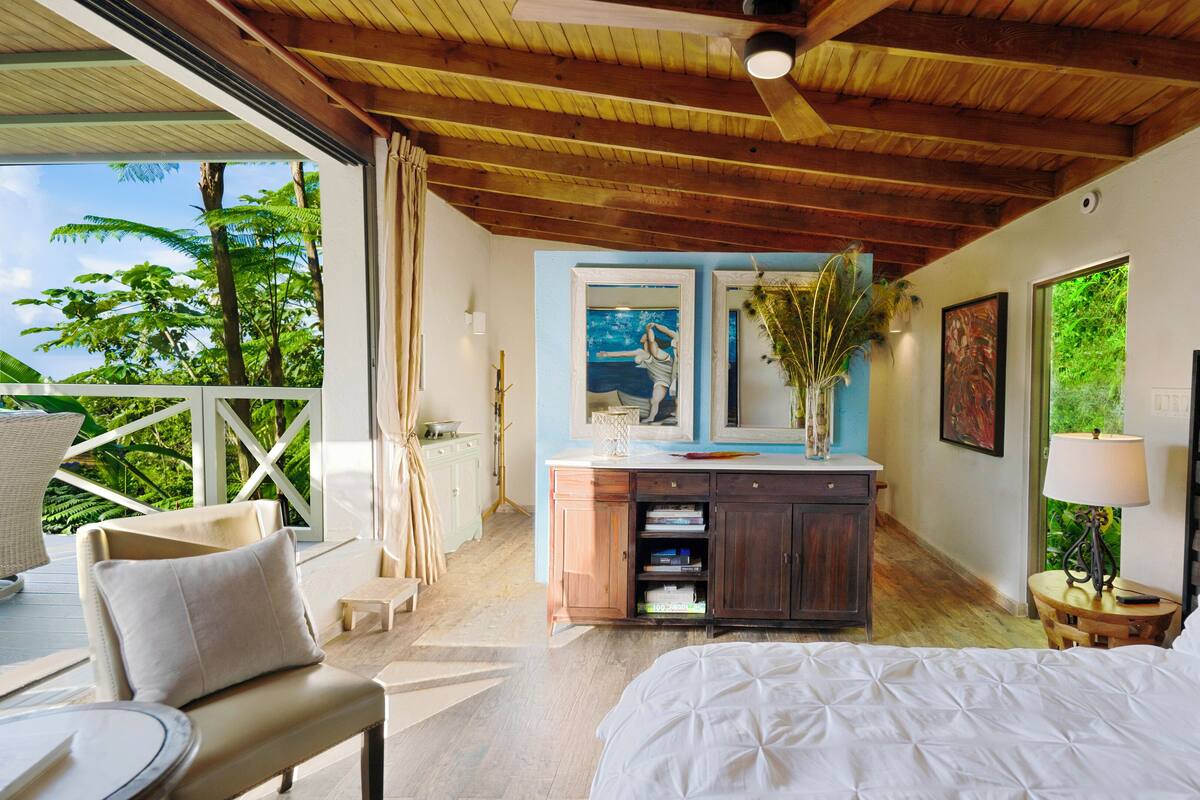 Une chambre à coucher avec un lit, un bureau, une chaise et une vue sur l’extérieur.