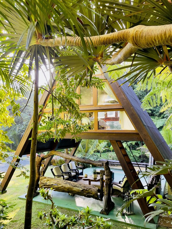 A treehouse with a hammock, wooden chairs, and a small table. - Mont Carpe Diem (Bayamon)