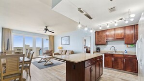 A modern kitchen with wooden cabinets, a central island, and pendant lighting.