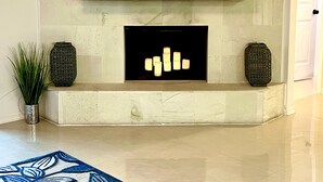 A fireplace with two levels of shelves, a door to the right, and a blue patterned rug on the floor. - Tall Palms Oasis (McAllen)