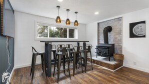 A modern kitchen with a central island, bar stools, pendant lighting, a built-in stove, and a window overlooking the outdoors. - Luxury Living-Kirkland: Stylish Home - Prime Spot! (Kirkland)