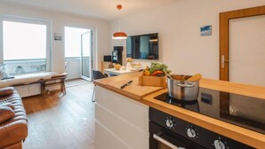 A modern kitchen with a stove, oven, and a dining area with a table and chairs.