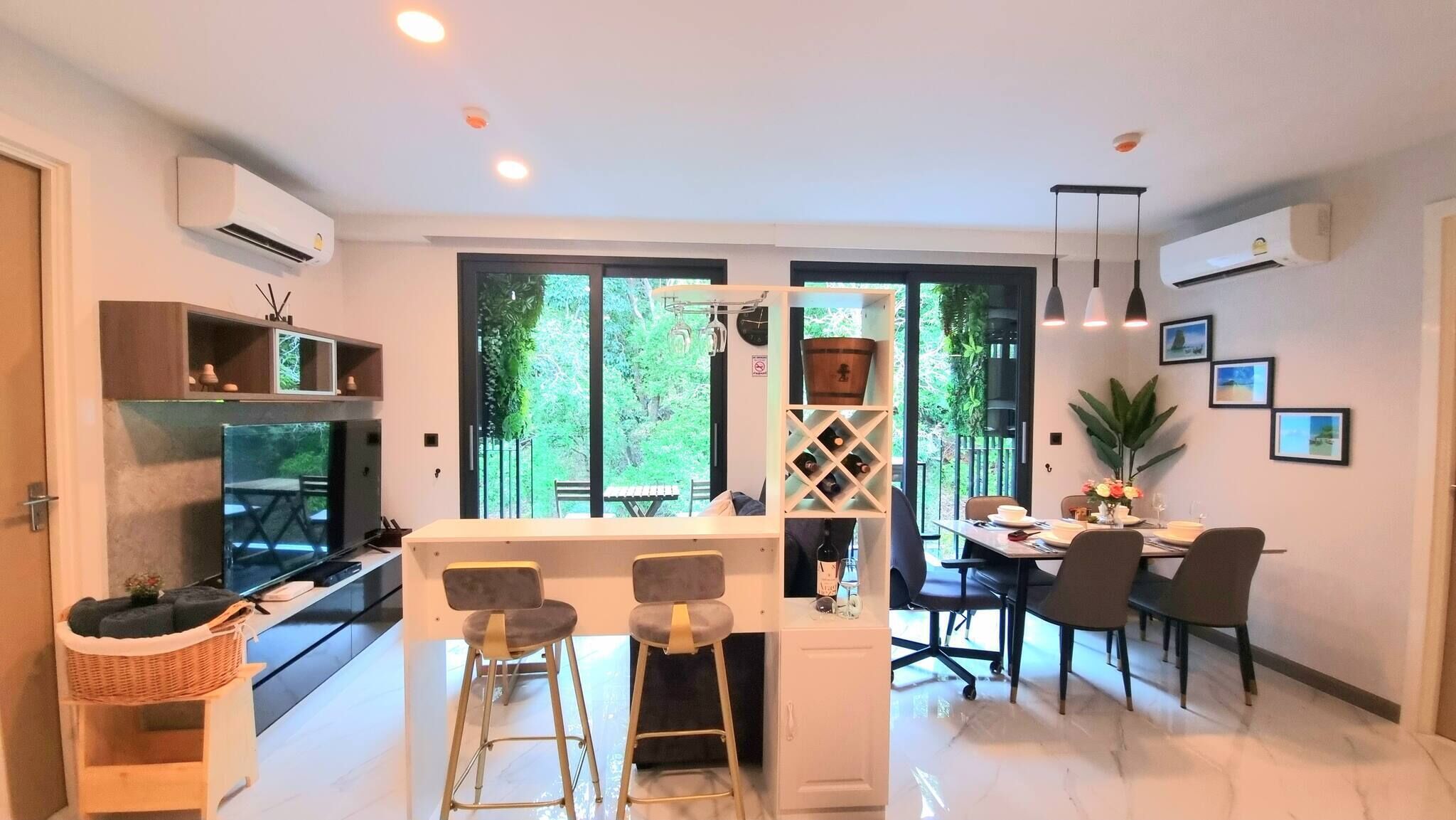 Una cucina moderna con zona pranzo, ampie finestre e vista su spazi verdi.