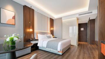 A modern hotel room with a large bed, bedside tables, a desk, and a chair.