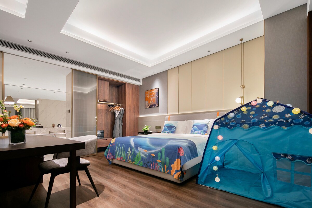 Una habitación de hotel moderna con una cama, una mesa de comedor, una kitchenette pequeña y una estructura parecida a una tienda de campaña.