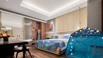 A modern hotel room with a bed, a dining table, a small kitchenette, and a tent-like structure.