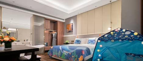 A modern hotel room with a bed, a dining table, a small kitchenette, and a tent-like structure.