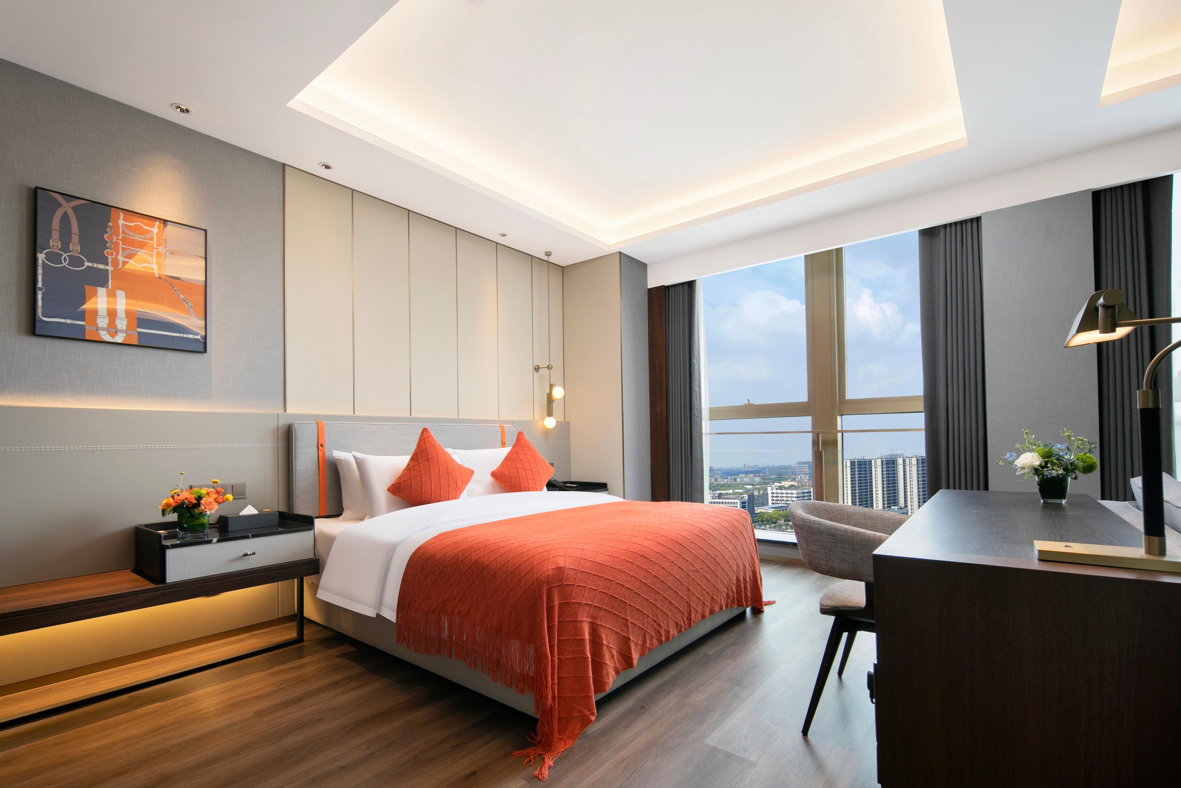 Une chambre d’hôtel moderne avec un grand lit, un bureau et une vue sur la ville.