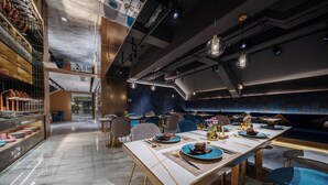 Un restaurante moderno con una larga mesa de comedor, sillas y una variedad de platos.