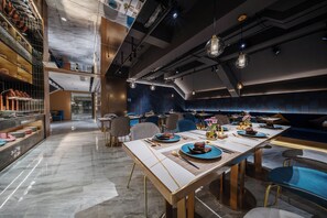 Un restaurante moderno con una larga mesa de comedor, sillas y una variedad de platos.
