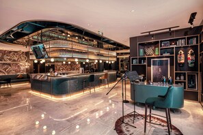 Zona de bar moderna con techo curvo, barra de varios niveles y diferentes opciones de asientos, incluyendo taburetes y sillas.