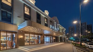 A hotel with a modern facade, large glass windows, and a prominent entrance with a canopy. - Manxin Hotel Hefei Jingkai District Pearl Plaza (Hefei)