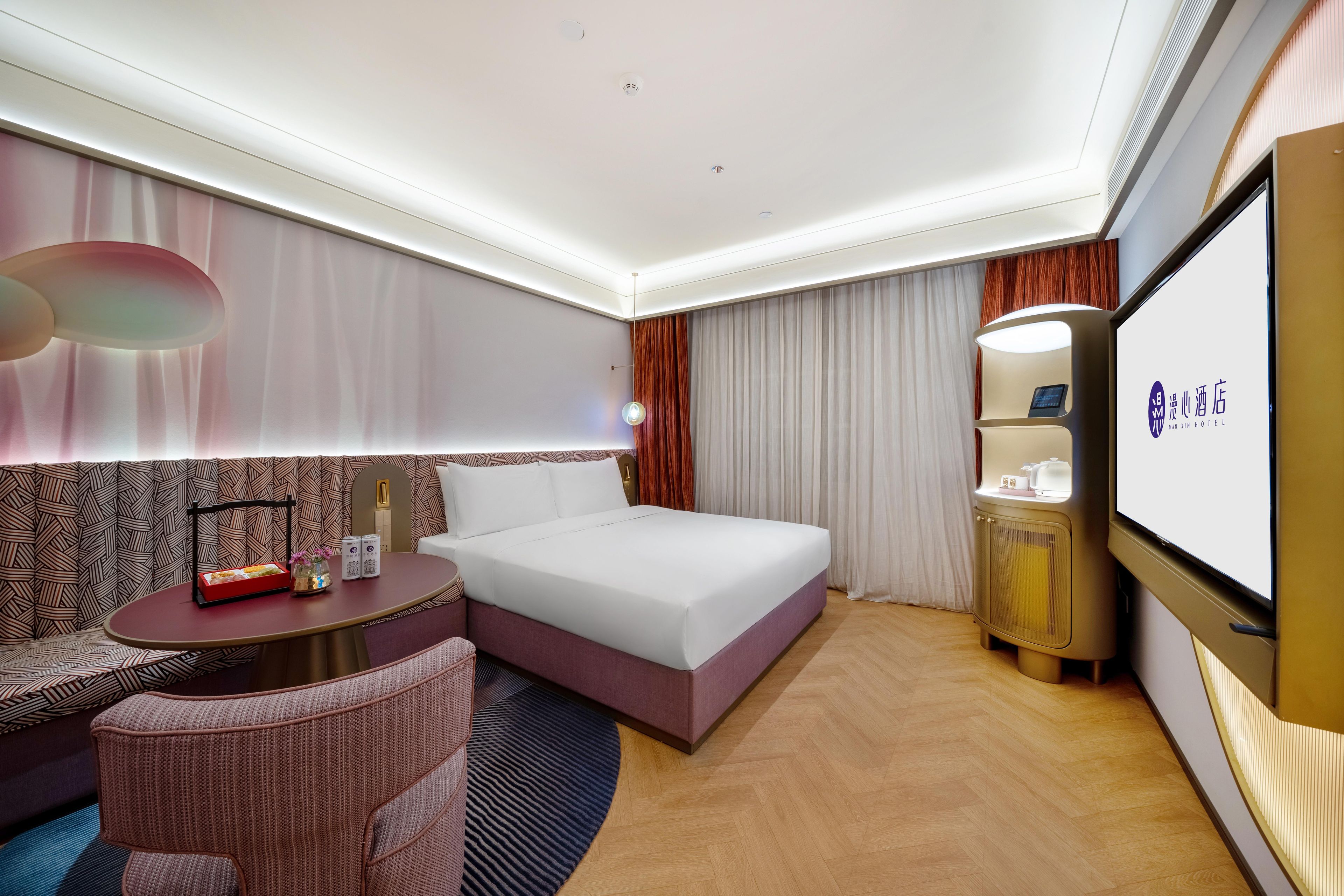 A hotel room with a bed, bedside table, and a TV.