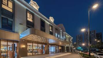 A hotel with a modern facade, large glass windows, and a prominent entrance with a canopy.