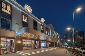 Un hotel con fachada moderna, amplios ventanales y una entrada destacada con toldo.