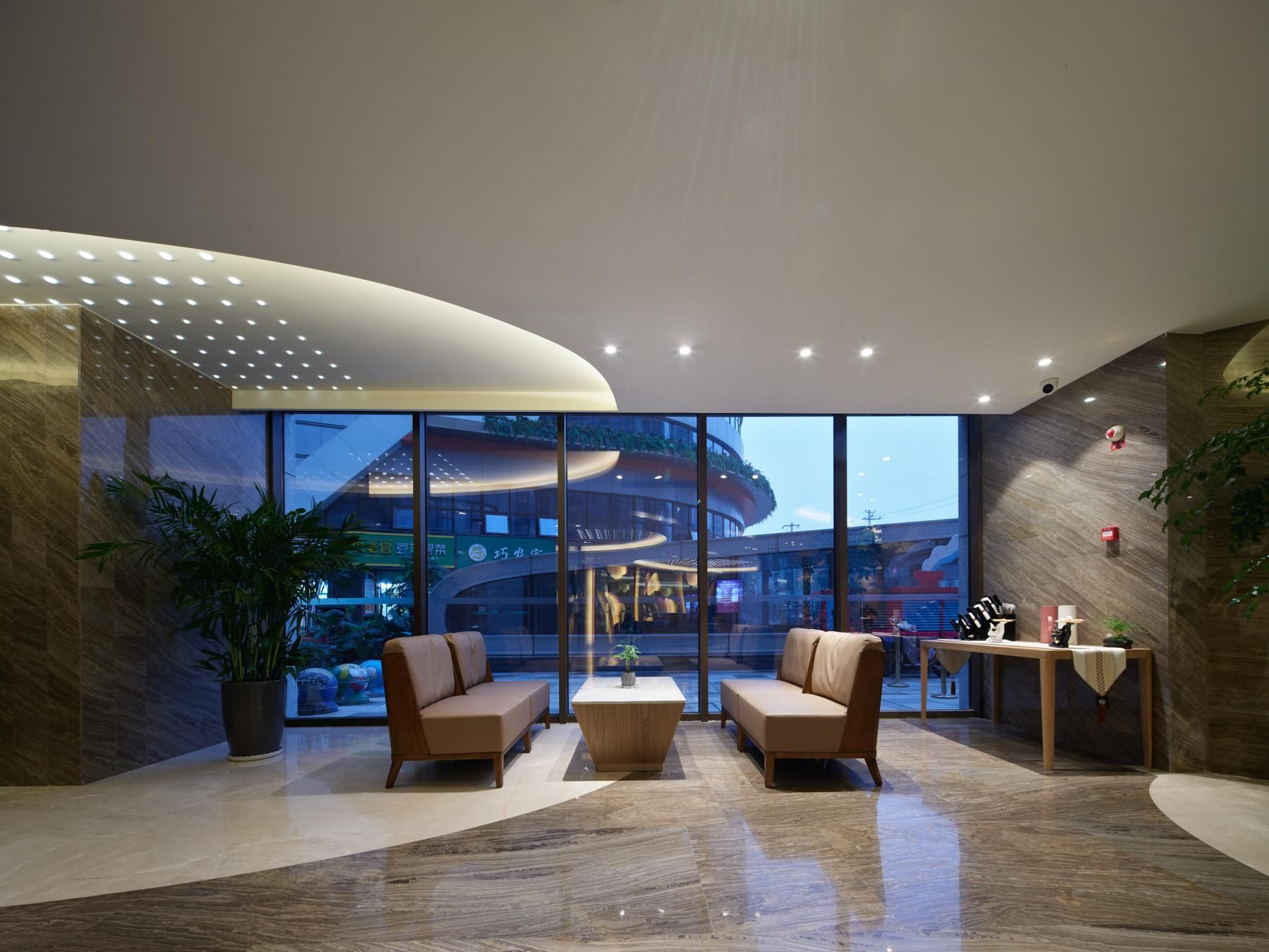 A modern lobby with two sofas, a coffee table, and a reception desk.