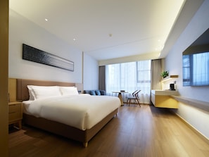 A modern hotel room with a large bed, a desk, and a chair. - Madison Hotel Xianyang Zhuquan Road Wanda Plaza (Xianyang)