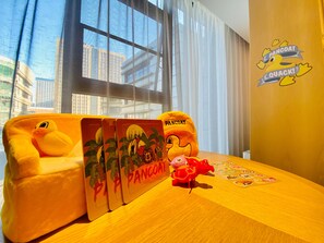 A room with a large window, a plush toy, a small table with a placemat, and a wall sticker. - Madison Hotel Xianyang Zhuquan Road Wanda Plaza (Xianyang)