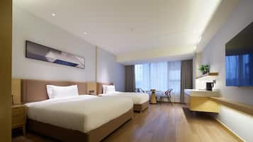 Una habitación de hotel moderna con una cama grande, un escritorio y una televisión.