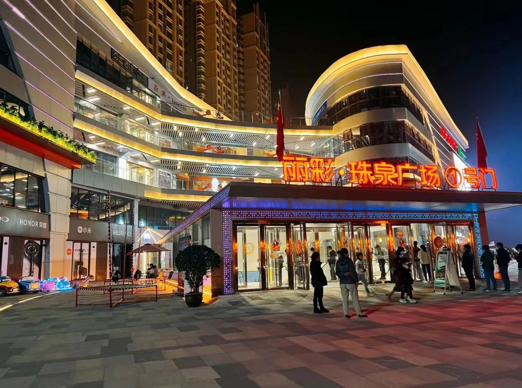 A modern hotel with a prominent entrance, multiple floors, and a well-lit facade.