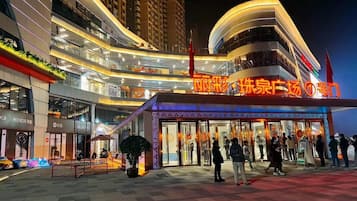 A modern hotel with a prominent entrance, multiple floors, and a well-lit facade.