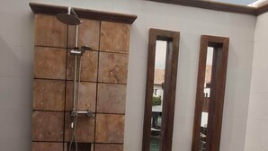 A modern bathroom with a shower, two mirrors, and a small garden area with artificial grass and pebbles. - Alpine GLX Port Dickson (Port Dickson)