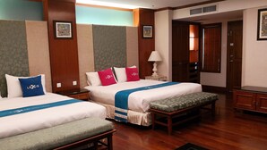 A hotel room with two beds, a bench, a nightstand, and a lamp. - Alpine GLX Port Dickson (Port Dickson)