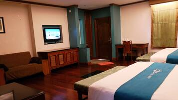 A hotel room with two beds, a TV, a desk, and a couch.