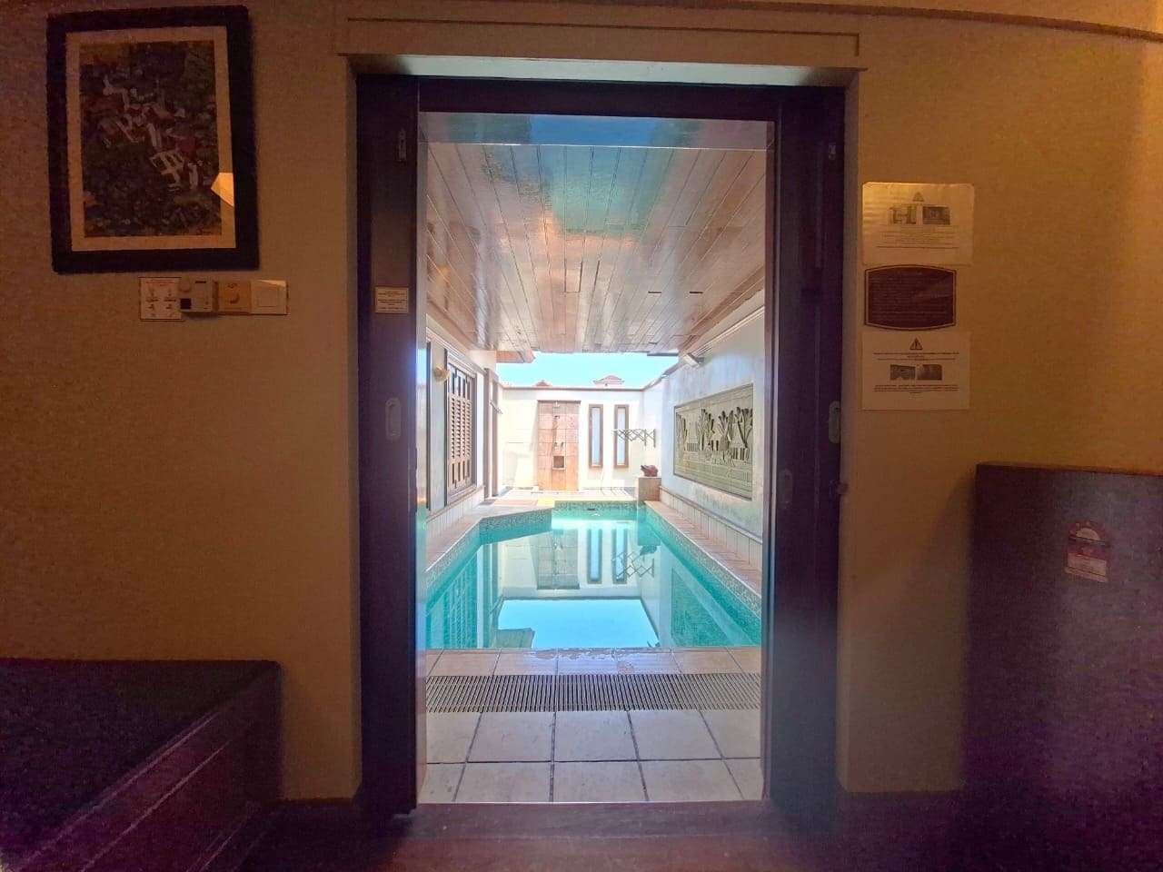 An indoor swimming pool with a view of the outside.