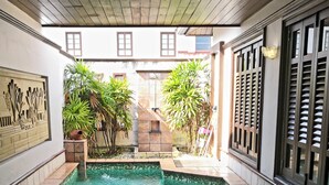A swimming pool with tiled edges, surrounded by walls with decorative panels and windows. - Alpine GLX Port Dickson (Port Dickson)