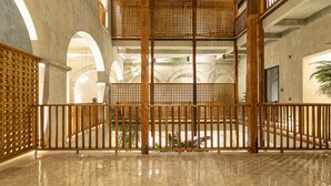 A spacious lobby with a high ceiling, a central staircase, and a decorative wooden fence. - Cinco Quintas Hotel Boutique (Cartagena)