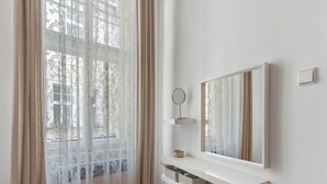 Un baño moderno con un ventanal grande, un espejo y estantes empotrados.