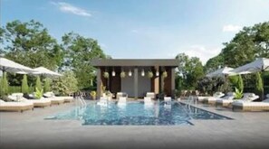 Relax by the pool surrounded by lush greenery and comfortable lounge chairs.