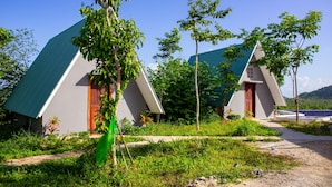 Two modern, triangular-roofed cottages with a natural, green landscape. - Sabay Farm (Kampot)