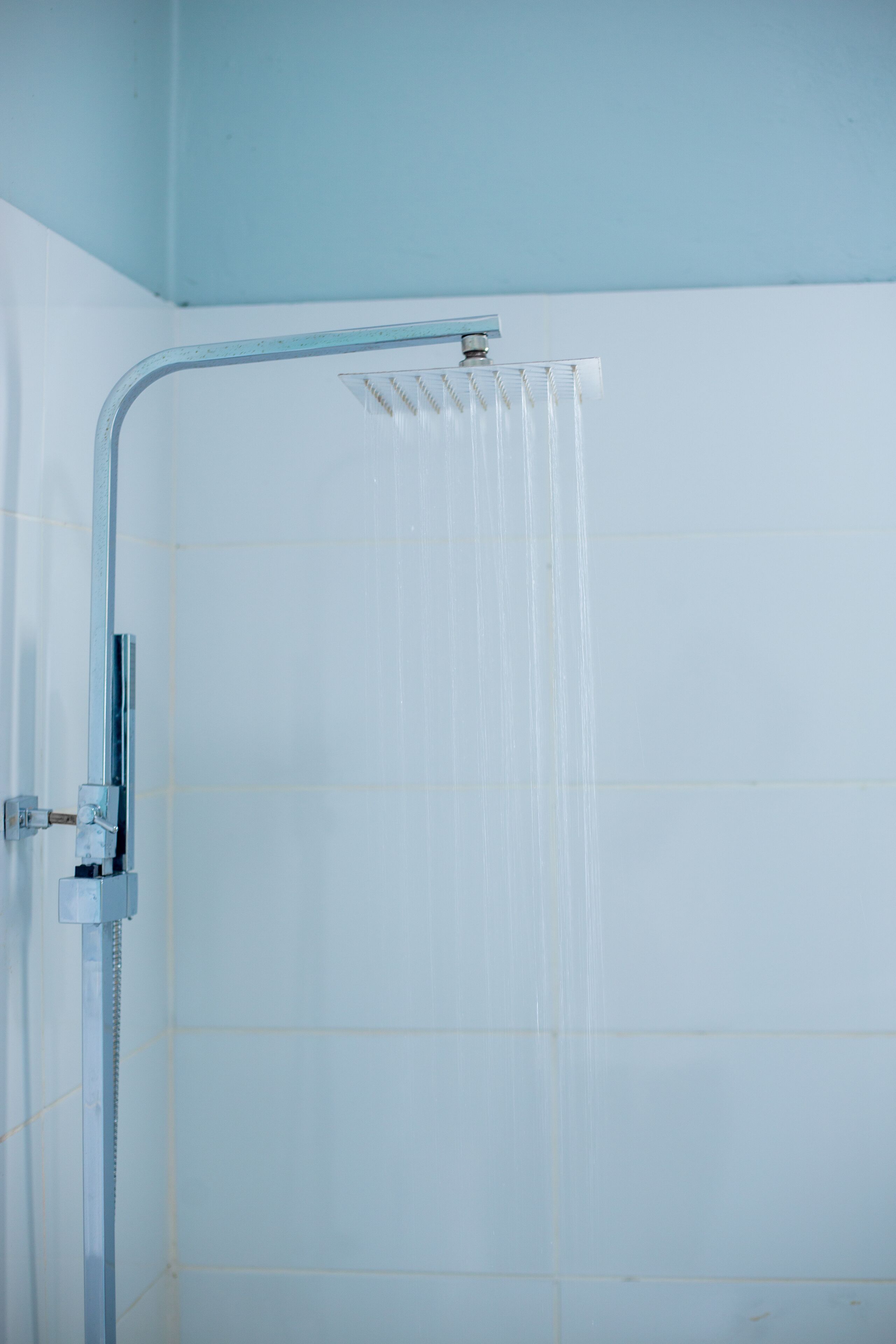 Eine Dusche mit Armatur aus Chrom und einer Glasabtrennung.